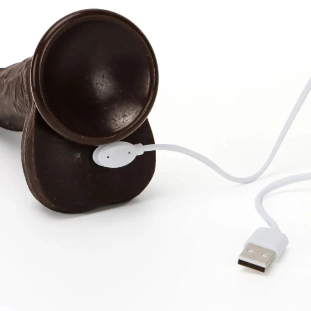 Black dildo with a white USB cable and connector on a white background