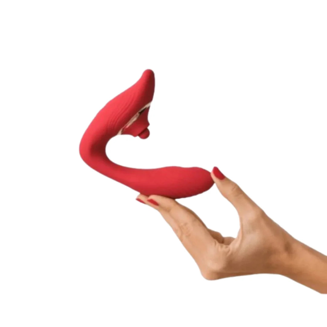 Red silicone vibrator held by a hand on a white background